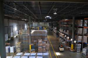 New Jersey 3rd party logistics; photo of the interior of a New Jersey public warehousing facility with a forklift stacking pallets on steel shelving.
