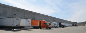 New York 3PL and Public Warehousing; photo of tractor trailers parked at warehouse loading dock.NY Fulfillment & 3PL Warehouse