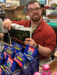 Employment Horizons program participant packs goody bags to help meet the fulfillment needs for The Creative Kitchen's "Kids Food Festival"