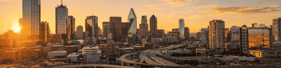 The Dallas skyline at sunrise semi trucks moving along major highways, representing Palisades Logistics 3PL services