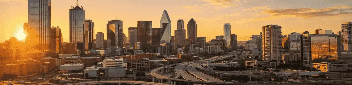 The Dallas skyline at sunrise semi trucks moving along major highways, representing Palisades Logistics 3PL services
